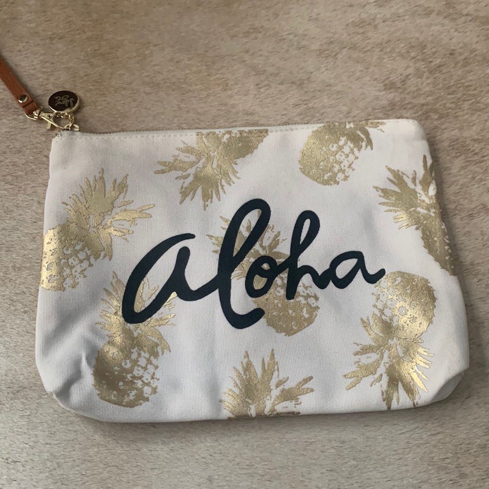 Large white wristlet with gold foil pineapple print from Hawaii.